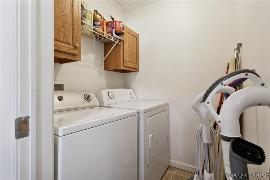 1413 Locust Grove Road Topping, VA 23169 - Photo 21 of 50 Laundry room with cabinets, light tile patterned floors, and washing machine and clothes dryer