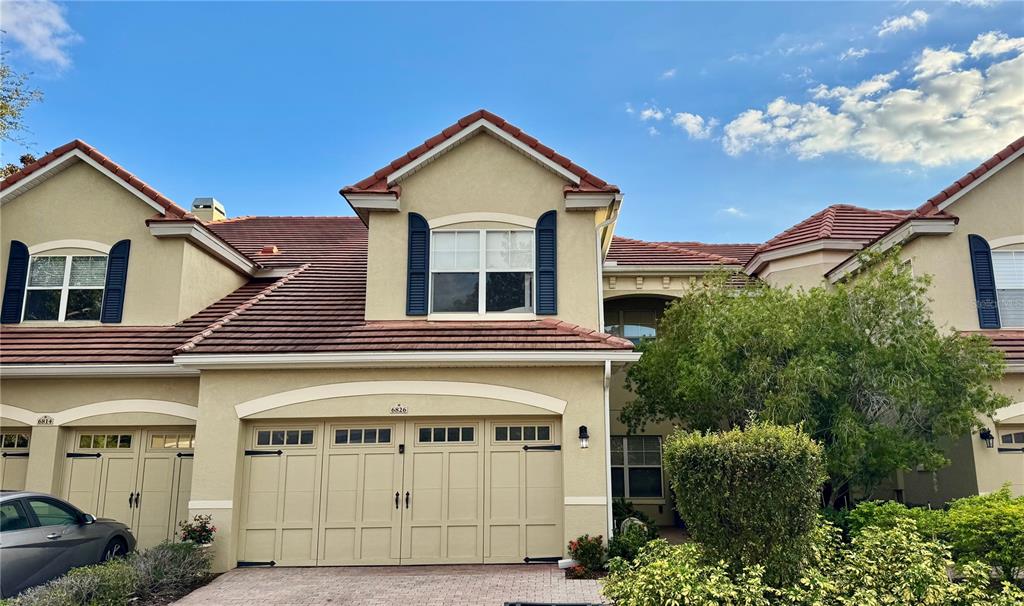 a view of a white house with large windows and a small yard