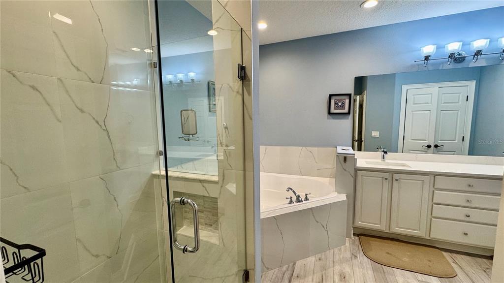 6826 Sorrento Street Orlando, FL 32819 - Photo 13 of 28 a bathroom with a double vanity sink a mirror and shower