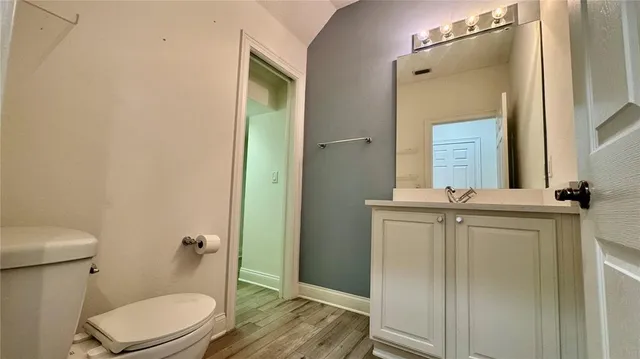 a bathroom with a granite countertop toilet sink and mirror