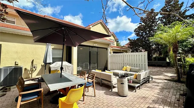 a view of a patio with couches table and chairs under an umbrella