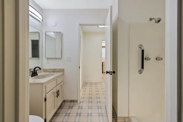 a bathroom with a granite countertop sink a toilet and shower