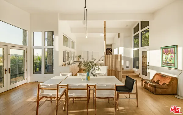 a dining room with furniture a chandelier and wooden floor