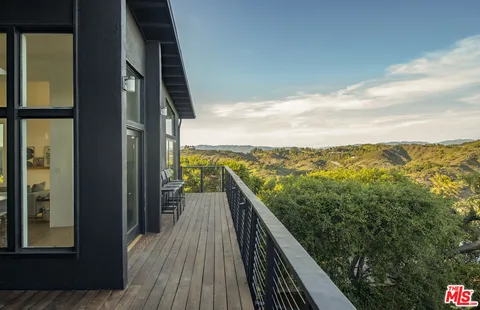 a view of a balcony with mountain view and wooden floor