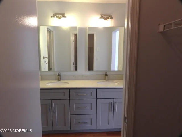 a bathroom with double vanity sinks and a mirror