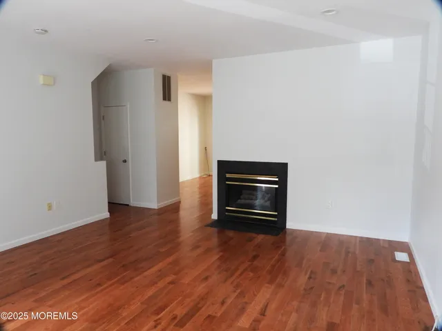 a room with wooden floor and a fireplace