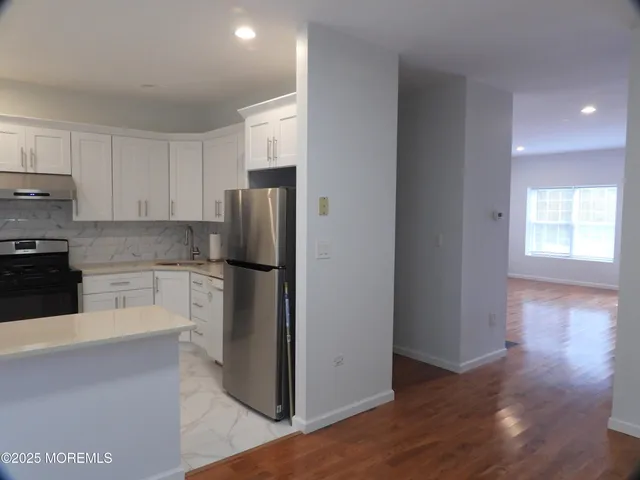 a kitchen with a refrigerator and a stove top oven