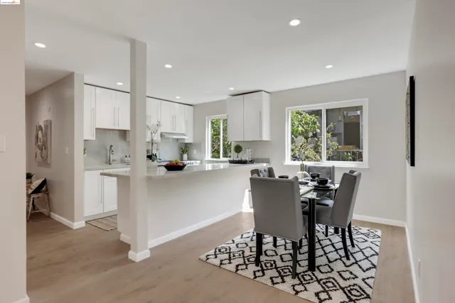 a kitchen with a dining table chairs and refrigerator