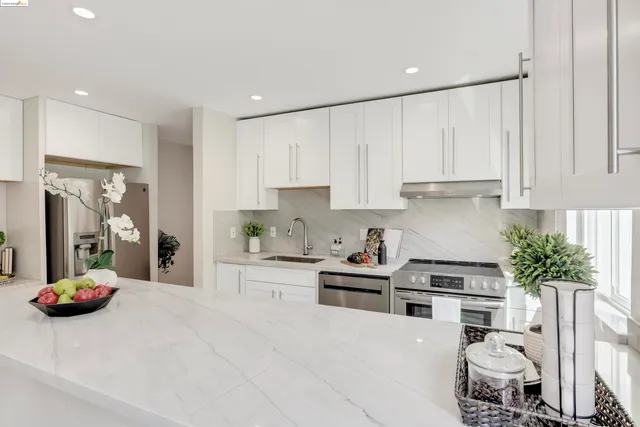 a kitchen with granite countertop a white cabinets and window