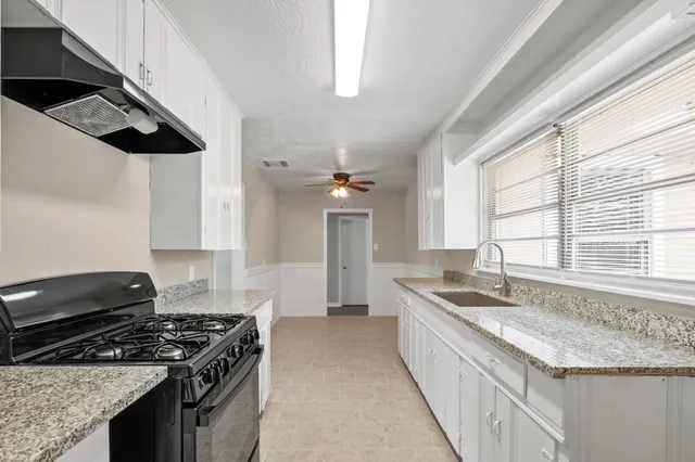 a kitchen with granite countertop a sink and a stove
