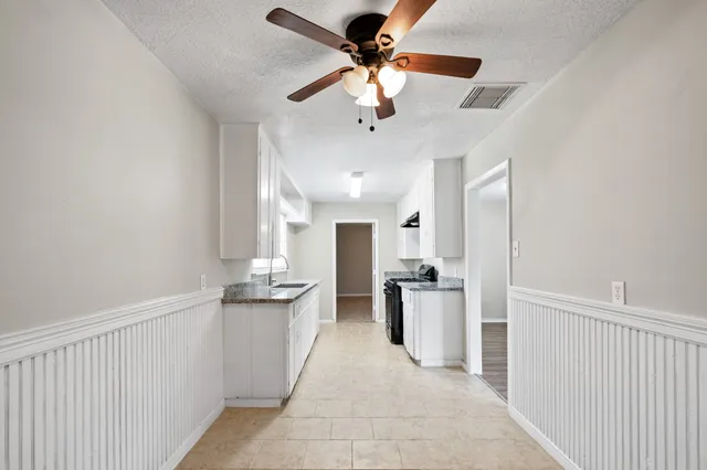 a kitchen with stainless steel appliances kitchen island granite countertop a refrigerator and a sink
