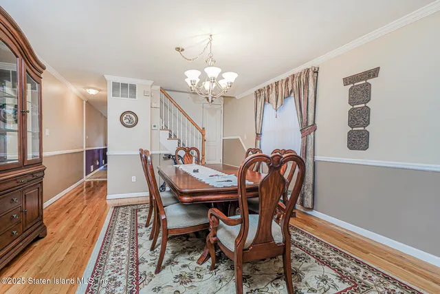 a dining room with furniture a chandelier and wooden floor