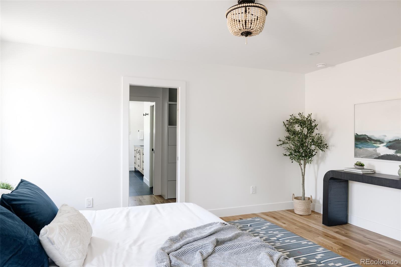 832 Adams Street Denver, CO 80206 - Photo 19 of 39 a bedroom with a bed and a potted plant