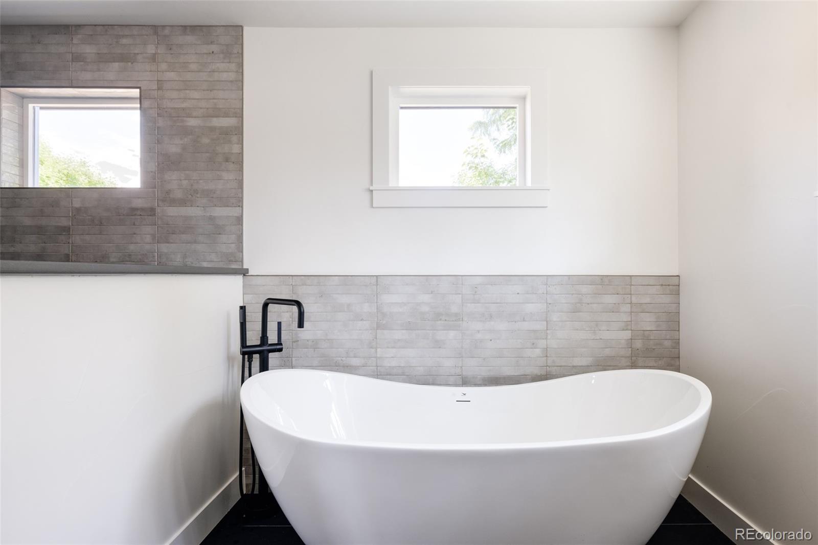 832 Adams Street Denver, CO 80206 - Photo 22 of 39 a white bath tub sitting in a bathroom