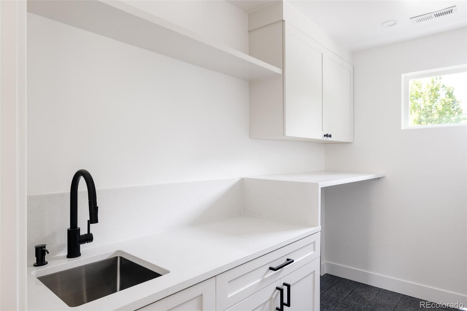 832 Adams Street Denver, CO 80206 - Photo 29 of 39 a kitchen with cabinets and a sink