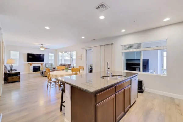 a kitchen with granite countertop stainless steel appliances white cabinets granite counter tops and a wooden floors