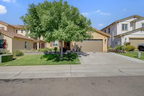 a front view of a house with a yard and a garage