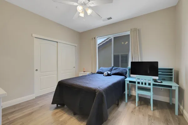 a bedroom with a bed and a flat tv screen on dresser
