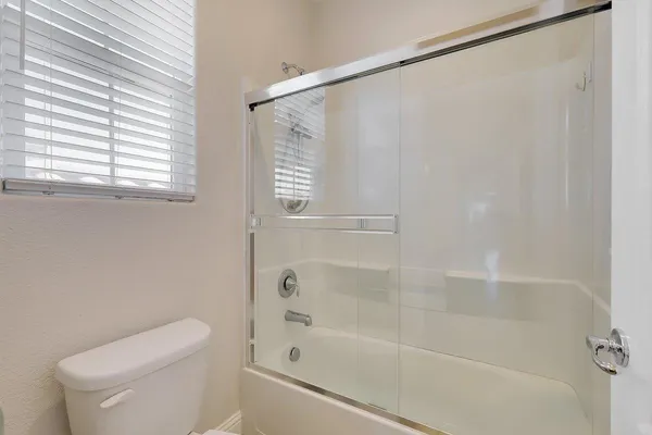a view of patio with chairs and table under an umbrella with a barbeque grill and plants