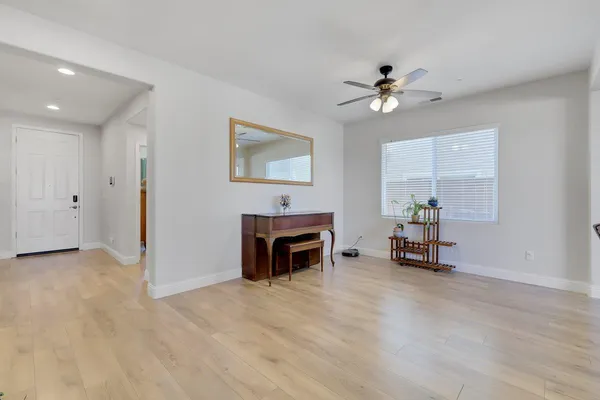 an empty room with furniture and a ceiling fan