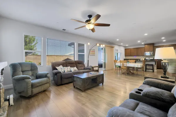 a living room with furniture kitchen and a large window