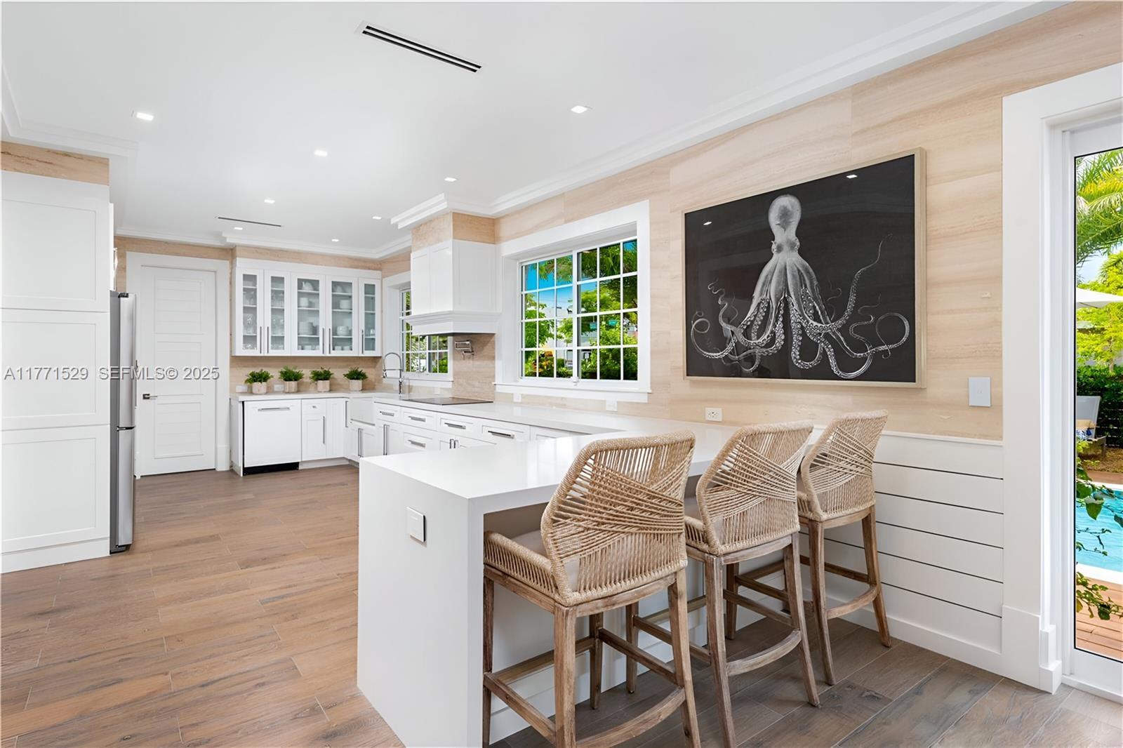2575 Pine Tree Drive Miami Beach, FL 33140 - Photo 14 of 36 a kitchen with stainless steel appliances granite countertop a stove and a refrigerator