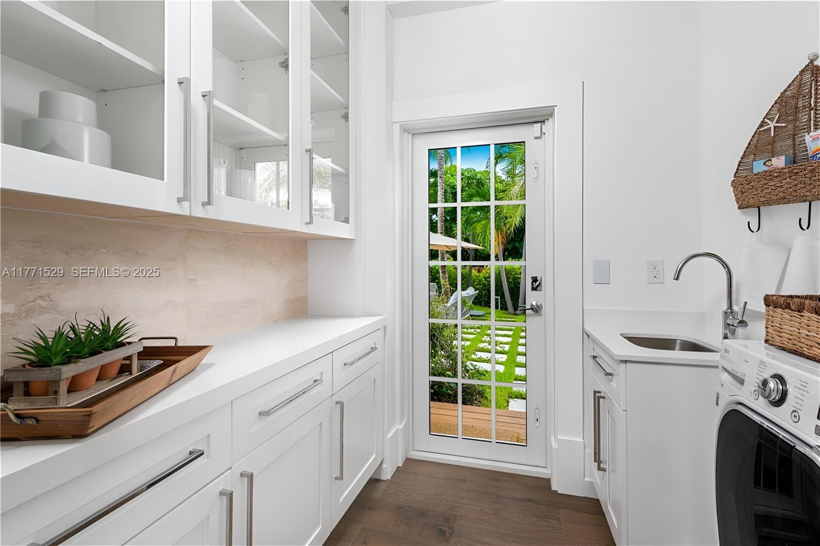 2575 Pine Tree Drive Miami Beach, FL 33140 - Photo 16 of 36 a kitchen with stainless steel appliances a sink a stove and white cabinets next to a window