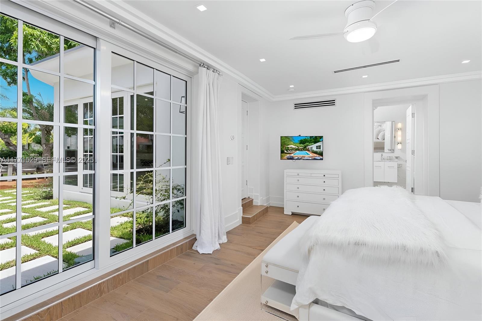 2575 Pine Tree Drive Miami Beach, FL 33140 - Photo 26 of 36 a bedroom with a bed and glass door