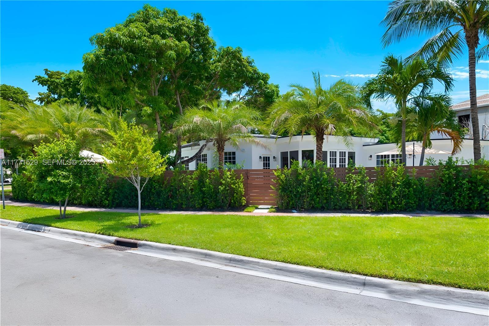 2575 Pine Tree Drive Miami Beach, FL 33140 - Photo 36 of 36 a view of a house with a yard and palm trees