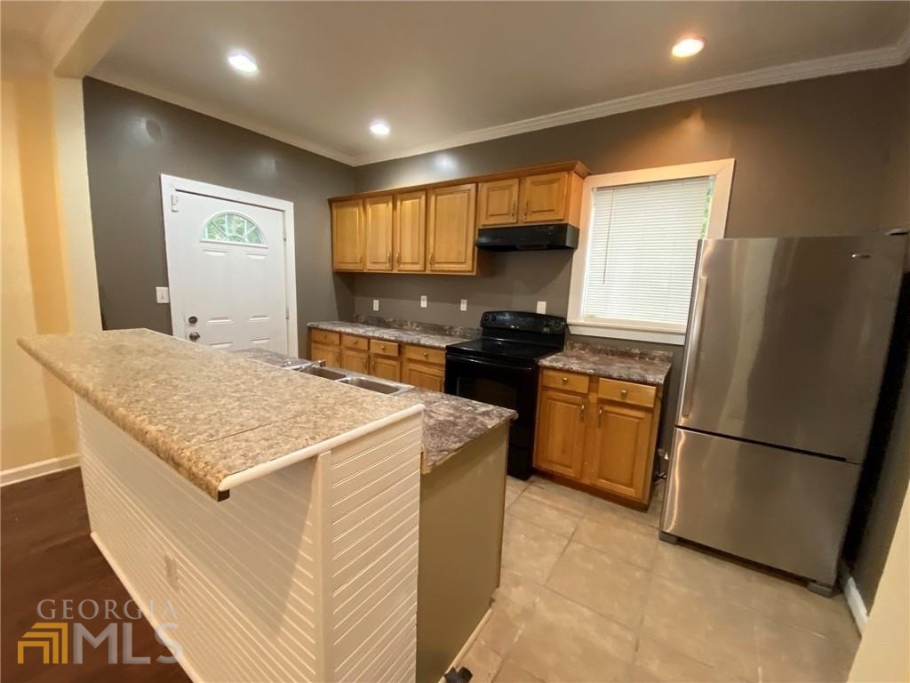 251 Holly Road Northwest Atlanta, GA 30314 - Photo 3 of 21 a kitchen with a refrigerator a stove a microwave and cabinets