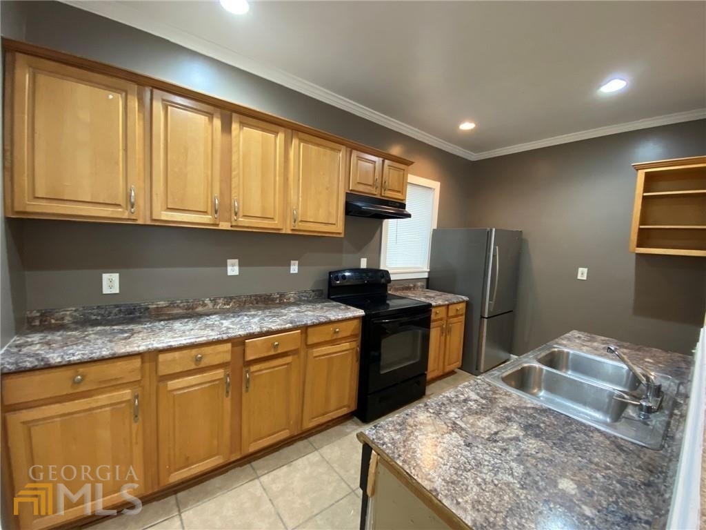 251 Holly Road Northwest Atlanta, GA 30314 - Photo 4 of 21 a kitchen with kitchen island granite countertop a sink stove and refrigerator