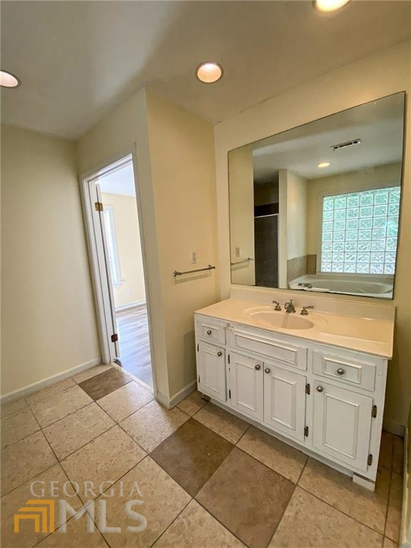 251 Holly Road Northwest Atlanta, GA 30314 - Photo 8 of 21 a spacious bathroom with a double vanity sink a mirror and a bathtub