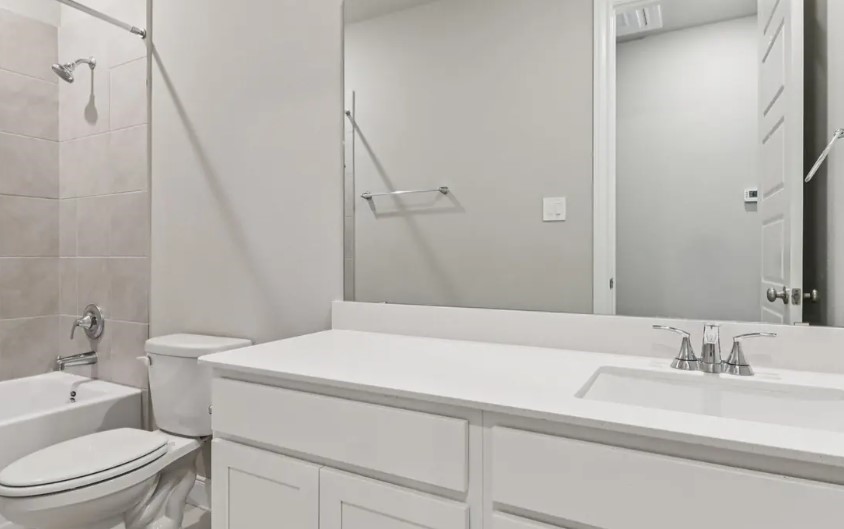 212 Raine Manor Montgomery, TX 77316 - Photo 7 of 12 a bathroom with a sink a toilet and a mirror
