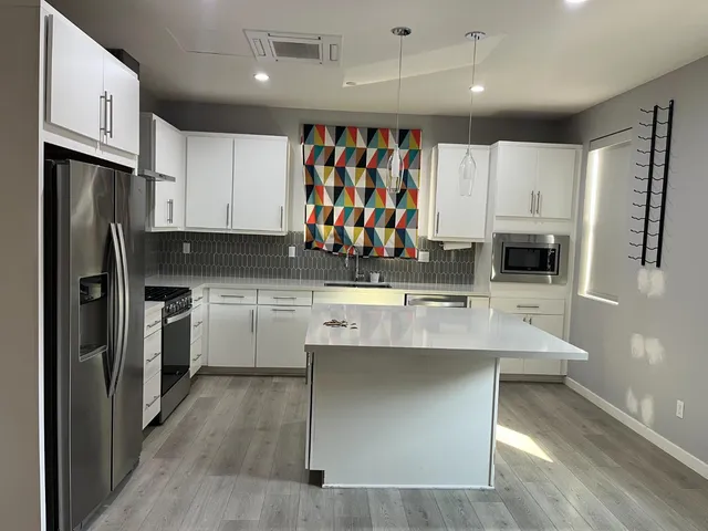 a kitchen with stainless steel appliances granite countertop a sink a stove and refrigerator