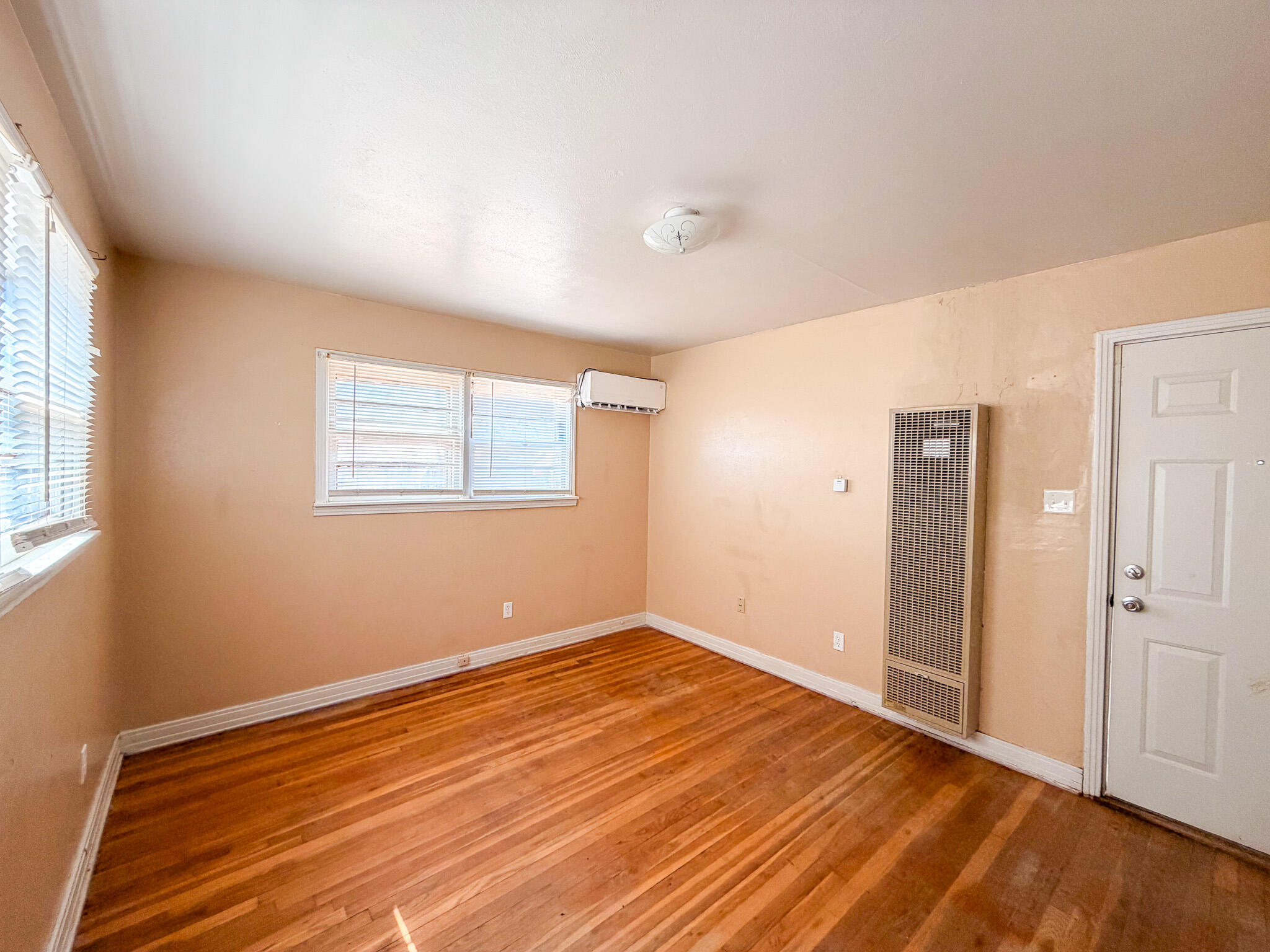 3207 Amherst Street Lubbock, TX 79415 - Photo 8 of 16 an empty room with wooden floor and windows