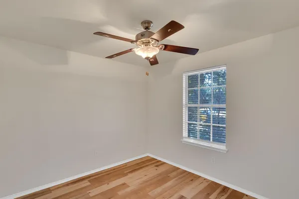 a view of a room with a ceiling fan and a window