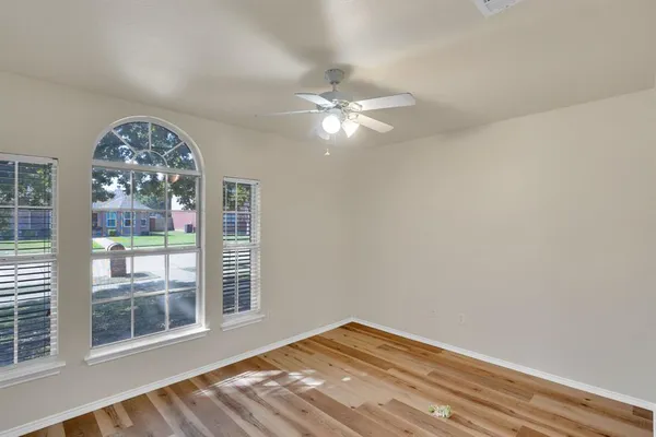 a view of a big room with wooden floor and a chandelier fan