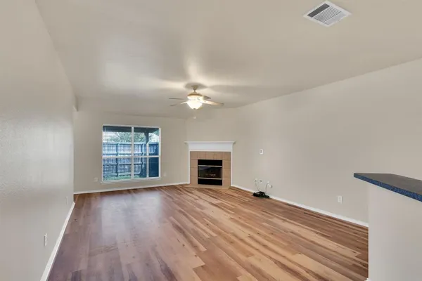 an empty room with windows and fireplace