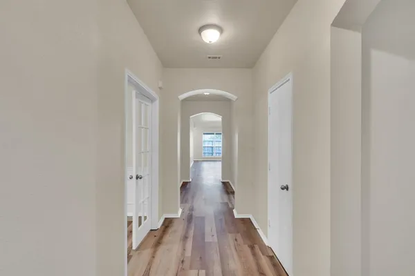a view of a hallway with wooden floor and staircase