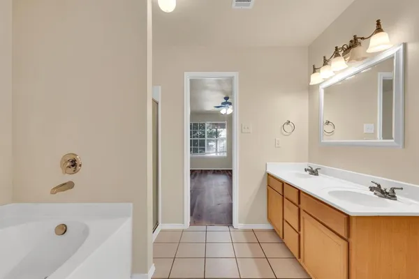a bathroom with a tub sink and mirror