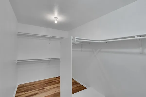 a view of walk in closet with empty racks