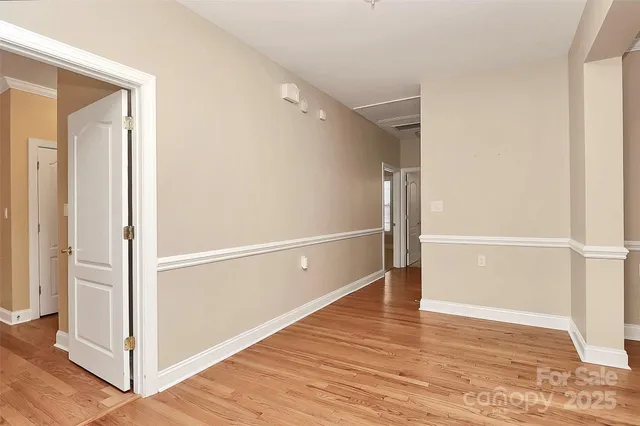 a view of an empty room with wooden floor