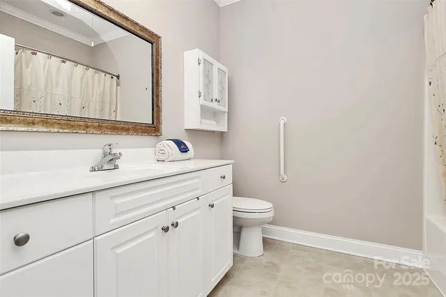 a bathroom with a toilet sink vanity and mirror
