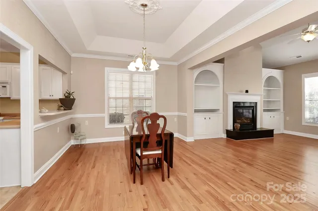 a view of a dining room with furniture a chandelier and wooden floor