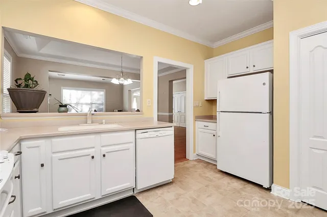 a kitchen with white cabinets and refrigerator