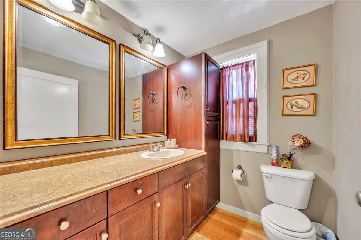 212 East Union Street Vienna, GA 31092 - Photo 27 of 62 a bathroom with a sink a toilet a mirror and shower