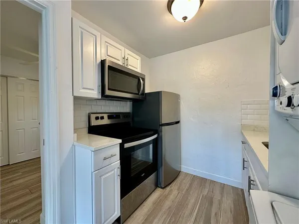 a kitchen with stainless steel appliances a stove microwave and sink