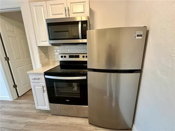 a kitchen with stainless steel appliances a refrigerator stove and microwave