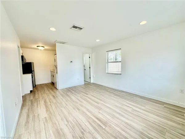 a view of empty room with wooden floor