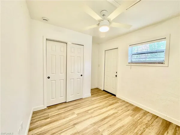 a view of a room with wooden floor and ceiling fan